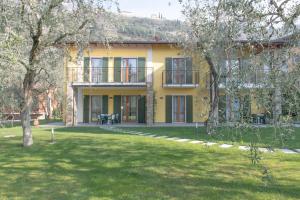 una casa amarilla con un patio delante en Casa Marisa, en Malcesine