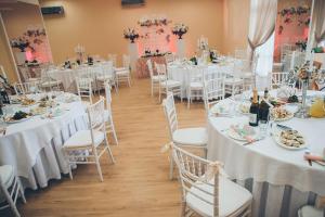 una habitación con mesas y sillas con mesas blancas y blancas en Veseliy Hotey, en Hurzuf