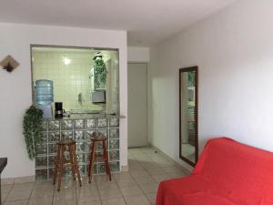 uma sala de estar com um sofá vermelho e uma cozinha em Apartament Rio Center em Niterói
