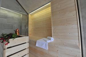 a bathroom with a shower with a wooden wall at La Madernassa Resort - Casalora Dimora Storica di Charme in Guarene