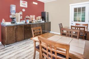 a kitchen and dining room with a table and chairs at Super 8 by Wyndham Quesnel BC in Quesnel