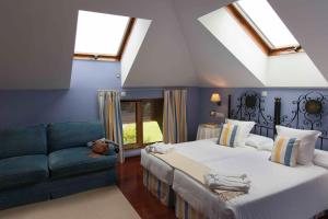 1 dormitorio con 2 camas y sofá en Casona de La Paca, en Cudillero