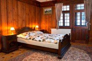 een slaapkamer met een bed en houten wanden en ramen bij Apartman Forstamt Glatzen Kladska in Mariánské Lázně