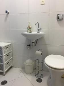 a bathroom with a sink and a toilet at Apartamento Praia in Guarujá