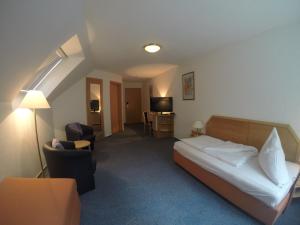 a hotel room with a bed and a desk at Hotel zum Wasserfall Garni in Oberndorf