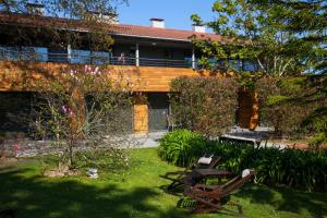 a yard with two benches and a building at Apartamentos Casona de la Paca in Cudillero