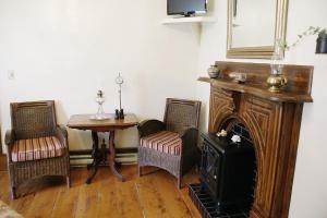 a living room with a table and a fireplace at Fisherman's Daughter B&B in Mahone Bay
