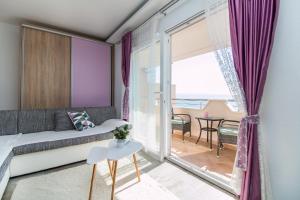 a living room with a couch and a large window at Apartments Rakuljic in Podstrana