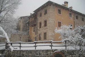 a large stone building with snow on the ground at Antica Corte Leguzzano B&B in San Vito di Leguzzano
