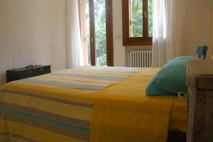 a bedroom with a bed with a yellow blanket at Antica Corte Leguzzano B&B in San Vito di Leguzzano