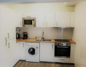 a kitchen with a washing machine and a microwave at Feel Funchal in Funchal