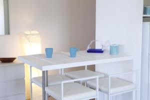 Flora في ألكامو مارينا: طاولة بيضاء عليها رفوف بيضاء واكواب زرقاء