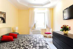 ローマにあるDomus Regina Colosseoのベッドルーム(赤い枕のベッド1台、テレビ付)