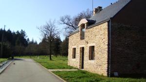 Campénéac的住宿－薩福克爾度假屋，一座古老的砖砌建筑,旁边是一条路
