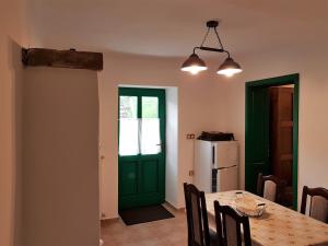 a dining room with a table and a green door at Pincesor Apartman in Villánykövesd