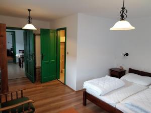 Pincesor Apartman في Villánykövesd: غرفة نوم مع أبواب منزلقة خضراء وسرير