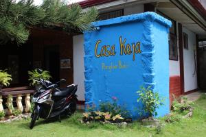 a scooter parked next to a blue sign in front of a house at CasaKeja Inn in Panglao Island