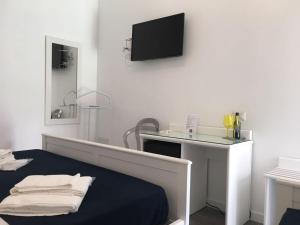サンタ・ドメーニカにあるB&B A casa di Picciのベッド1台、壁にテレビが備わる客室です。