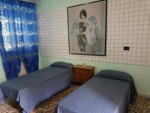 ManoppelloにあるLa Casetta Di Via Faraのベッド2台が備わる部屋、壁に絵が飾られた部屋