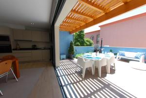 a patio with a table and chairs and a kitchen at Serenity in Jardim do Mar