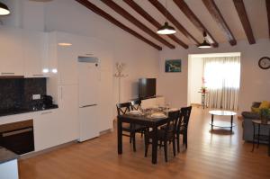 a kitchen and living room with a table and chairs at ApartSuits Tarragona Rambla Nova 24 in Tarragona