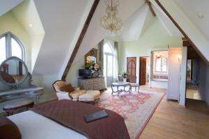 a bedroom with a bed and a chandelier at The French Country House, Tauranga in Omokoroa Beach