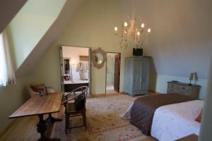 a bedroom with a bed and a table and a mirror at The French Country House, Tauranga in Omokoroa Beach +17 photos
