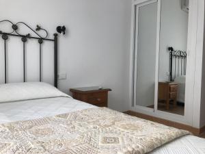 ネルハにあるEasy Nerja Apartmentsのベッドルーム(ベッド1台、大きな鏡付)