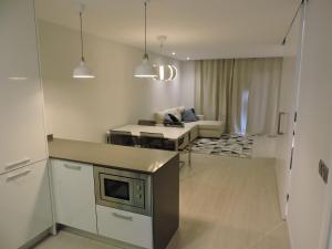 een keuken en een woonkamer met een bank bij Sao Rafael - Apartamento Studio in Albufeira