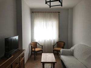 a living room with a couch and a tv at Easy Nerja Apartments in Nerja