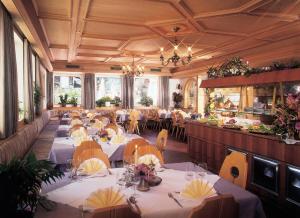 une salle à manger avec des tables et des nappes blanches dans l'établissement Hotel Klotz, à San Leonardo in Passiria