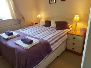 a bedroom with a large bed with towels on it at The Brambles B&B in Waterbeach