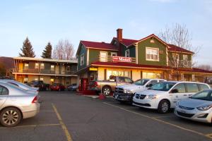a parking lot with cars parked in front of a building at Motel Saint-Hilaire in Mont-Saint-Hilaire