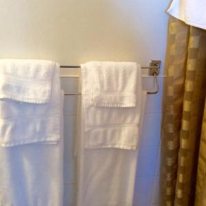 2 toallas blancas colgando de un toallero en el baño en Motel Saint-Hilaire, en Mont-Saint-Hilaire