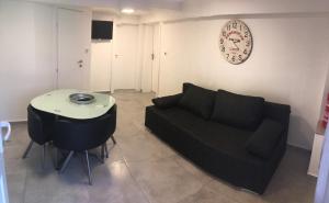 sala de estar con sofá y mesa en New Apartments, en Zagreb