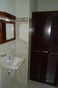 ein Badezimmer mit einem Waschbecken, einem Fenster und einem Spiegel in der Unterkunft Hotel La Gran Sultana in Granada