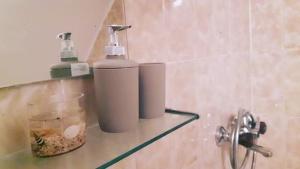 two soap dispensers sitting on a shelf in a bathroom at Apartment Anna Vis in Vis