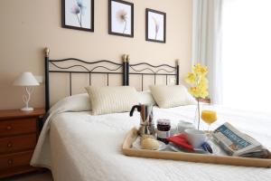 a tray with food and drinks on a bed at Apartamentos Lido in Benidorm