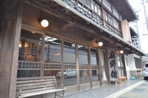 a building with a bench in front of a store at Asanokan in Ise