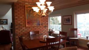 a dining room with a table and a brick wall at Casa Loma BnB in West Kelowna