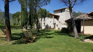 a chair sitting in the grass in front of a building at I Terzieri Country House in Ferentillo