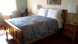 a bedroom with a bed with a blue floral bedspread at Casa Loma BnB in West Kelowna