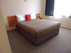 Un dormitorio con una cama con una almohada roja. en Broadview Motel, en Cheviot