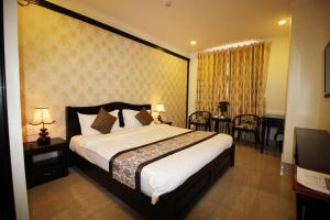 una camera da letto con un letto grande e una sala da pranzo di Royal Dalat Hotel a Da Lat Altre 37 foto