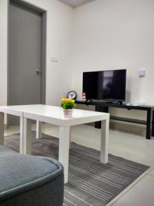 a living room with a white table and a tv at Apartment Suite Cyberjaya by Host Assist in Cyberjaya