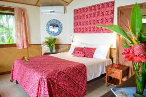 um quarto com uma cama com um cobertor vermelho em Le Vasa Resort em Fuailalo
