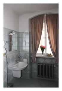uma casa de banho com um lavatório, um WC e uma janela. em Prague Golden Age em Praga