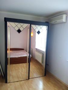 SalavatにあるАпартаменты для Двоихのガラスドア、ベッドが備わる客室です。