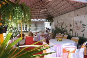 a restaurant with white tables and chairs and plants at Terrace Gardens in Bangalore