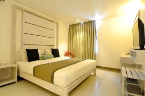 1 dormitorio con 1 cama grande y TV en Ivy Lane Colombo, en Colombo